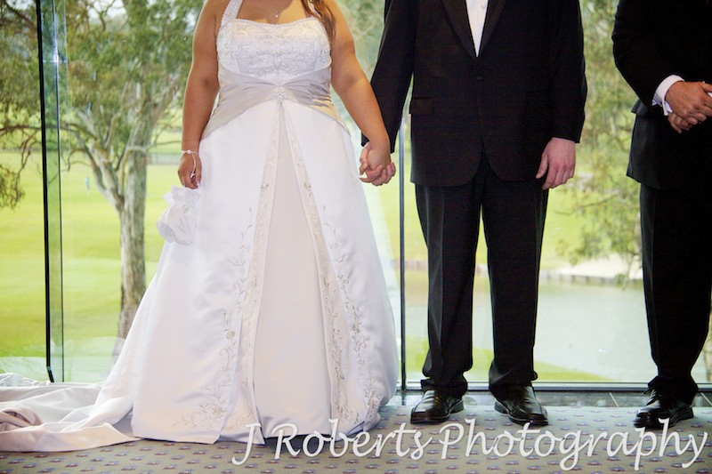 Bride and groom holding hands during ceremony - wedding photography sydney